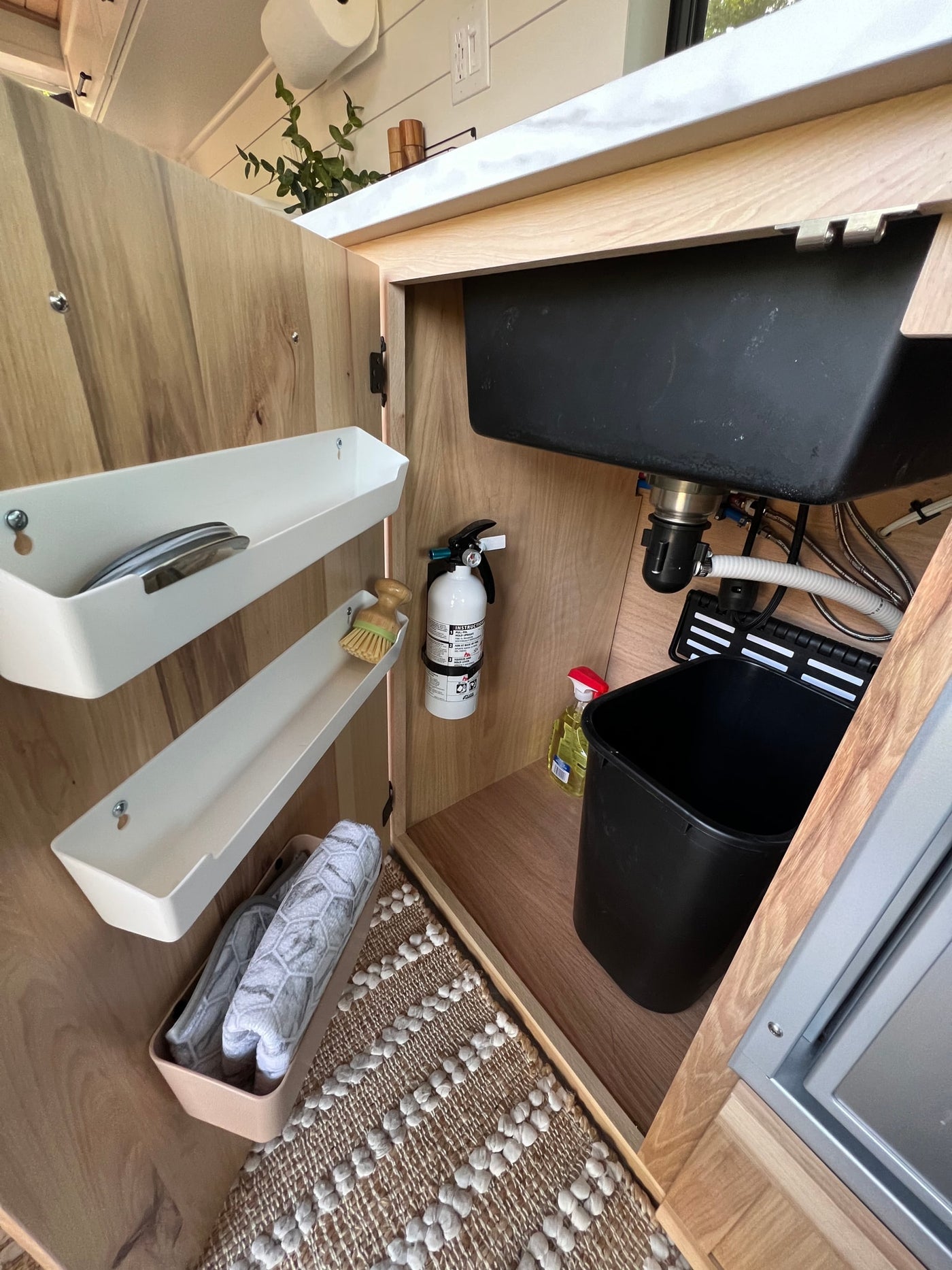  and a stylish rug.|Inside a stylish RV rental: light wood kitchen with Dometic fridge — photo 9
