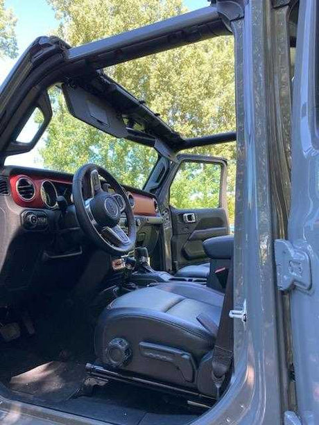 Inside an adventure-ready RV rental: a rugged vehicle's open-air interior with steering wheel and driver's seat.