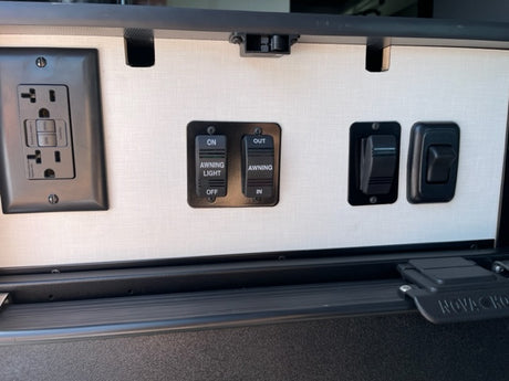 RV rental: Interior panel showing GFCI outlet, awning controls, and light switches. All essential for your journey.