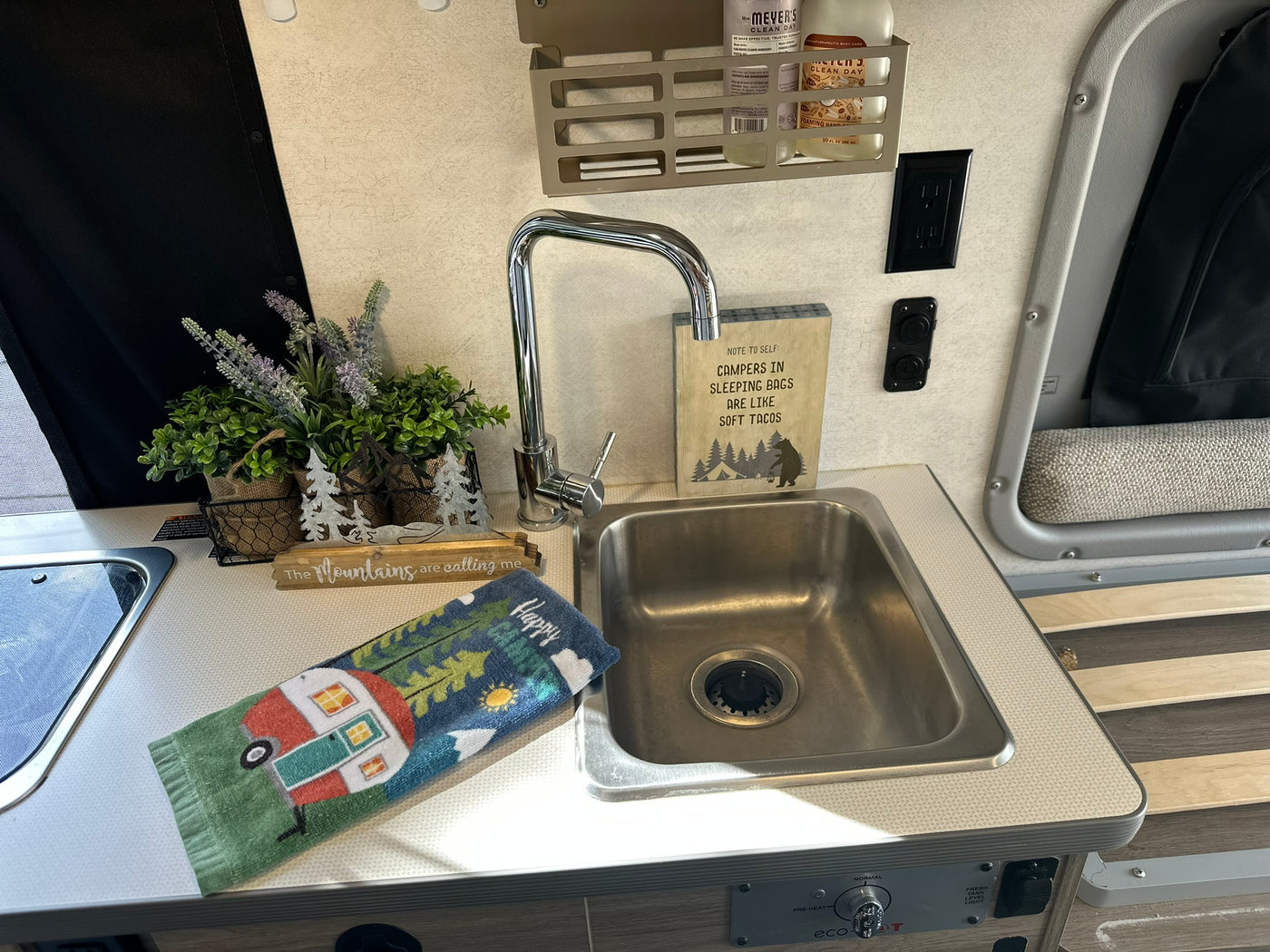 This RV rental's compact kitchen features a sink, faucet, and witty camping signs like "soft tacos." Adventure-ready! — photo 6