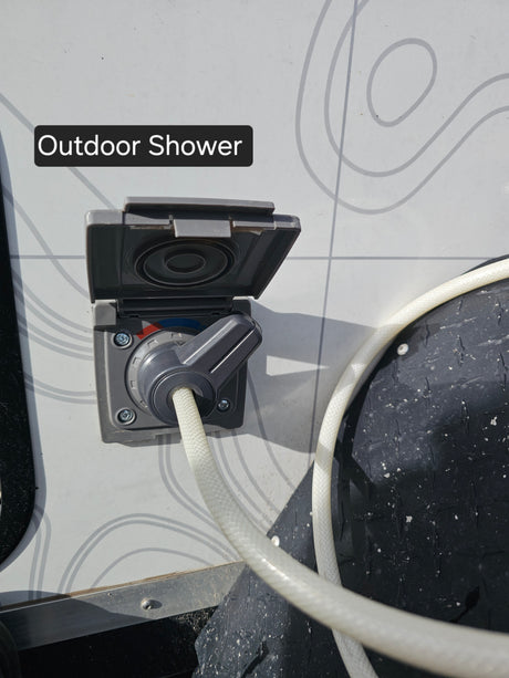 Connect to the outdoor shower on your RV rental. Hose attached, with hot & cold water indicators visible for convenient use.