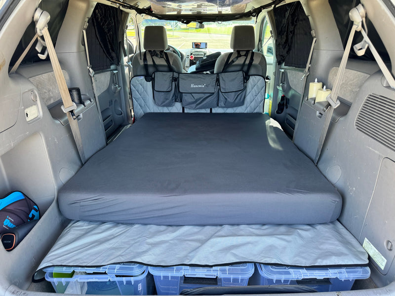 RV rental alternative: Minivan interior transformed for car camping. Features a comfortable bed, under-bed storage, and privacy curtains. — photo 7