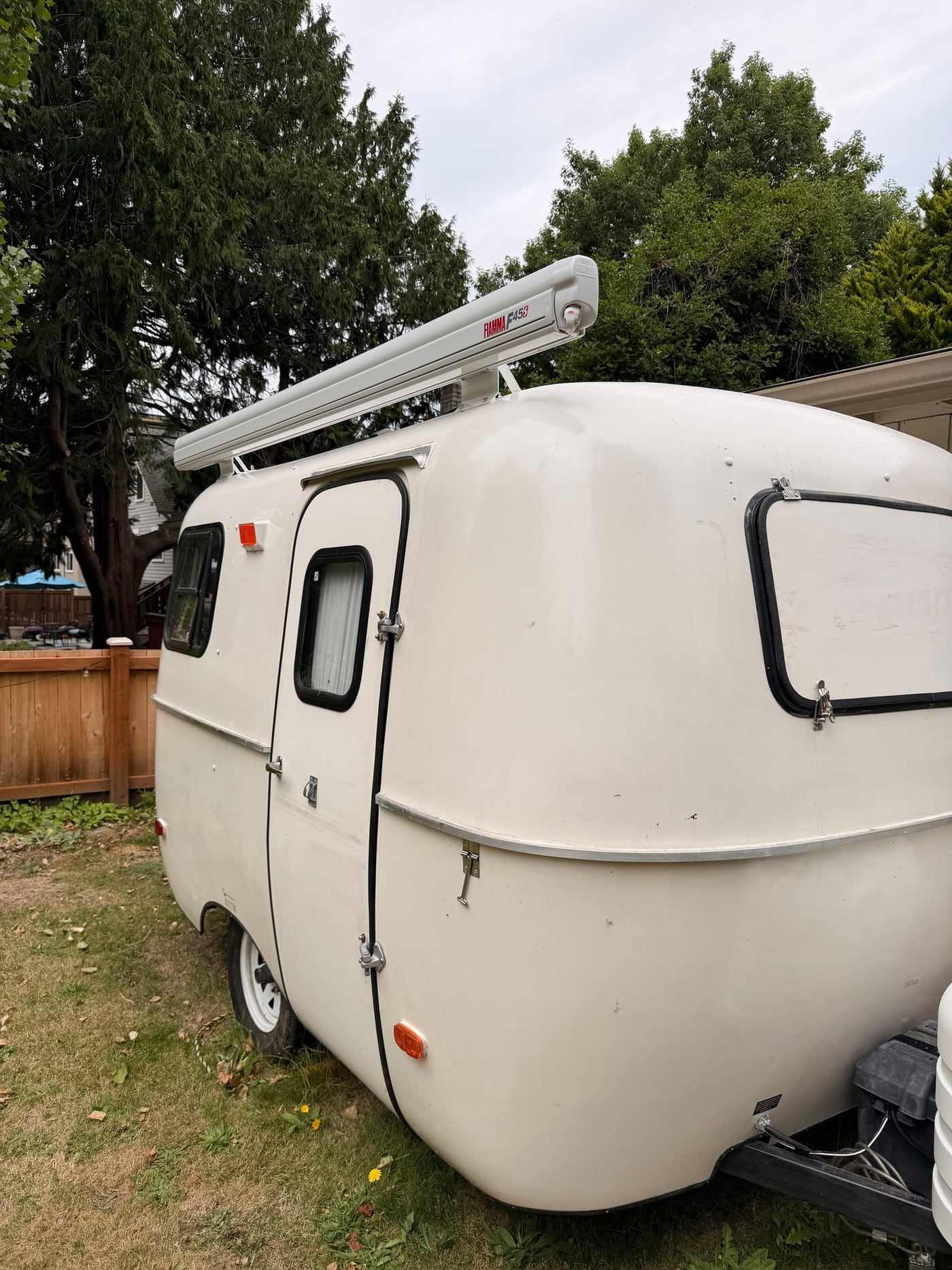  parked on grass. Consider this cozy rv rental for your next trip!|This charming white vintage travel trailer — photo 4