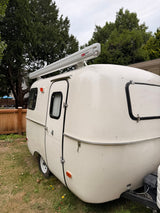  parked on grass. Consider this cozy rv rental for your next trip!|This charming white vintage travel trailer