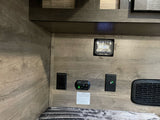 RV rental interior: audio system, safety alarm, and power outlets by the bed. Key features for comfort and safety.