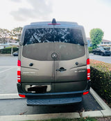 Dark grey Mercedes-Benz Sprinter van (RV rental option) from the rear, parked outdoors.