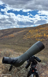 Spotting scope set up in vibrant autumn hills. Ideal for wildlife spotting; a perfect RV rental adventure destination.
