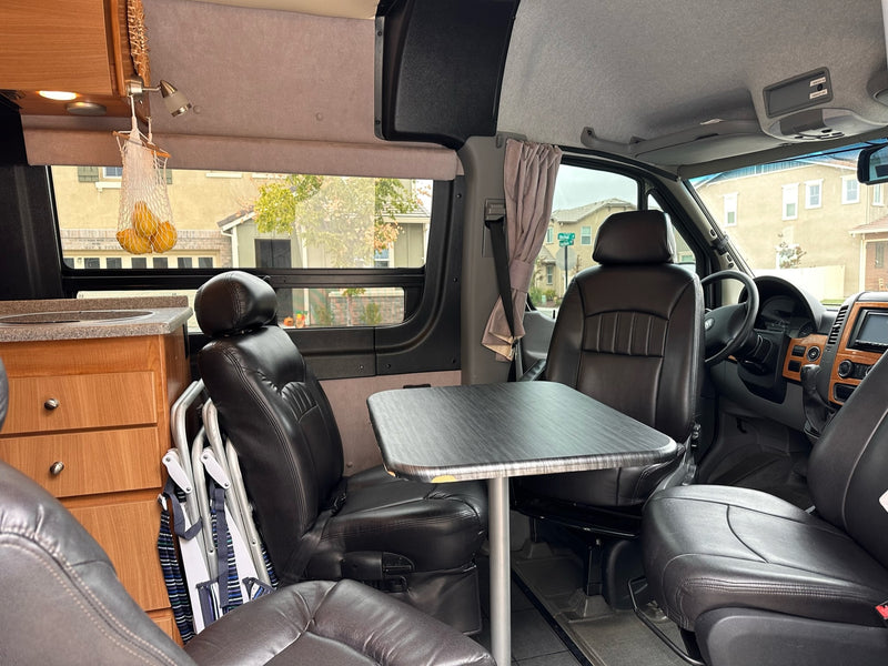 and a clear view of the road ahead.|Cozy RV rental interior featuring a comfy bed with a warm cable knit blanket — photo 10