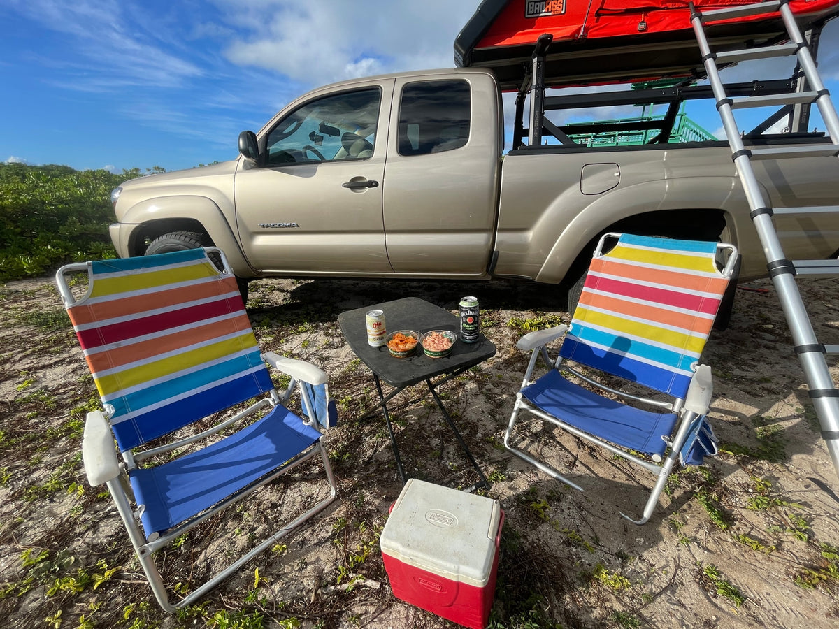 A truck with rooftop tent, chairs, & cooler create an outdoor rv rental adventure scene. — photo 11