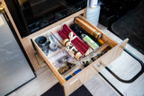 RV rental kitchen drawer, perfectly organized with cooking essentials: foil, measuring cups, and various utensils.