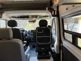 Inside this spacious RV rental, the front cabin, dashboard, and seats are visible, with overhead storage and a seat organizer.