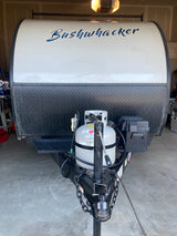 Front of a Bushwhacker travel trailer, ideal for an **rv rental** adventure. Features propane tank & hitch.