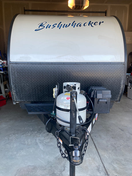 Front of a Bushwhacker travel trailer, ideal for an **rv rental** adventure. Features propane tank & hitch.