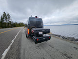 This Sprinter RV rental, equipped with storage, rests by a scenic lake, ready for adventure.