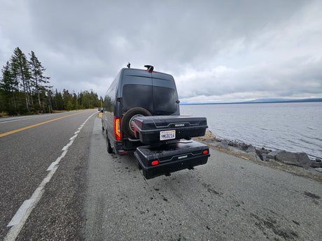 This Sprinter RV rental, equipped with storage, rests by a scenic lake, ready for adventure.