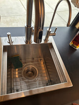Modern stainless steel kitchen sink in an RV rental, complete with a sleek faucet, sponge, and dark counter space.