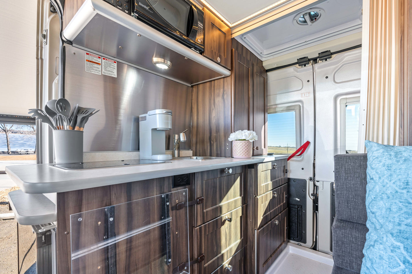 Step inside this RV rental's sleek kitchen, complete with a microwave, sink, coffee maker, and smart storage.