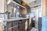 Step inside this RV rental's sleek kitchen, complete with a microwave, sink, coffee maker, and smart storage.