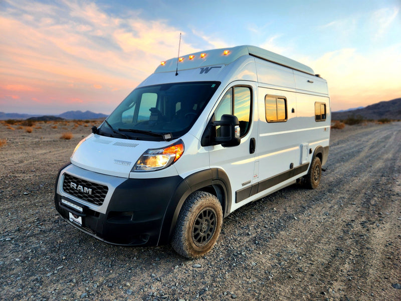 White off-road camper van RV rental awaits adventure on a gravel desert road — photo 1