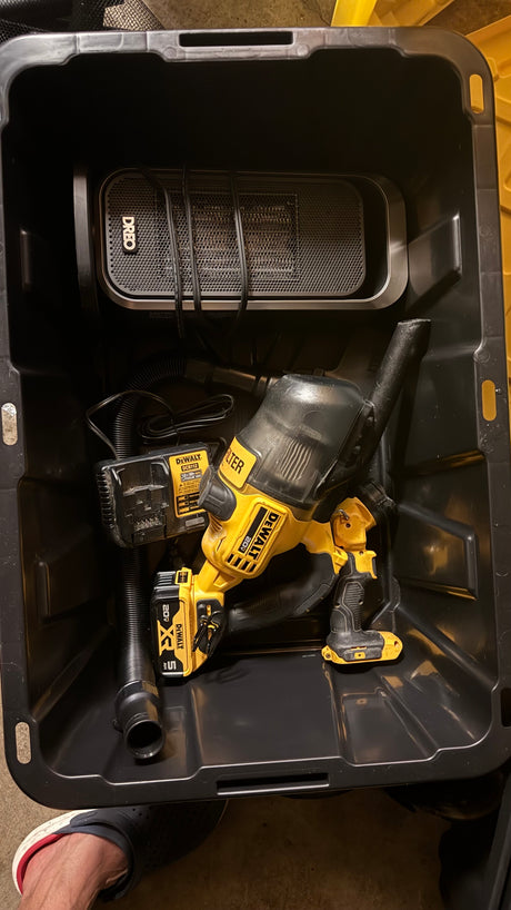 RV rental organization: DeWalt 20V vacuum, charger, and Dreo portable heater neatly stored in a black bin for travel.