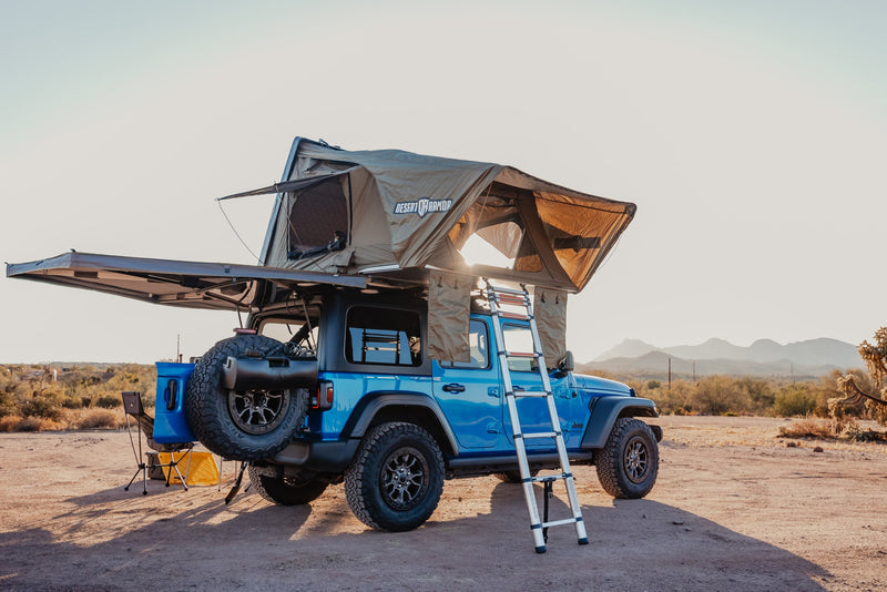 Blue Jeep with a rooftop tent and awning set up in the desert, offering a unique camping experience. Consider for your rv rental. — photo 20