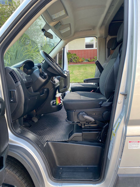 Step inside this RV rental! View of the driver's seat, steering wheel, and dashboard in a spacious camper van.