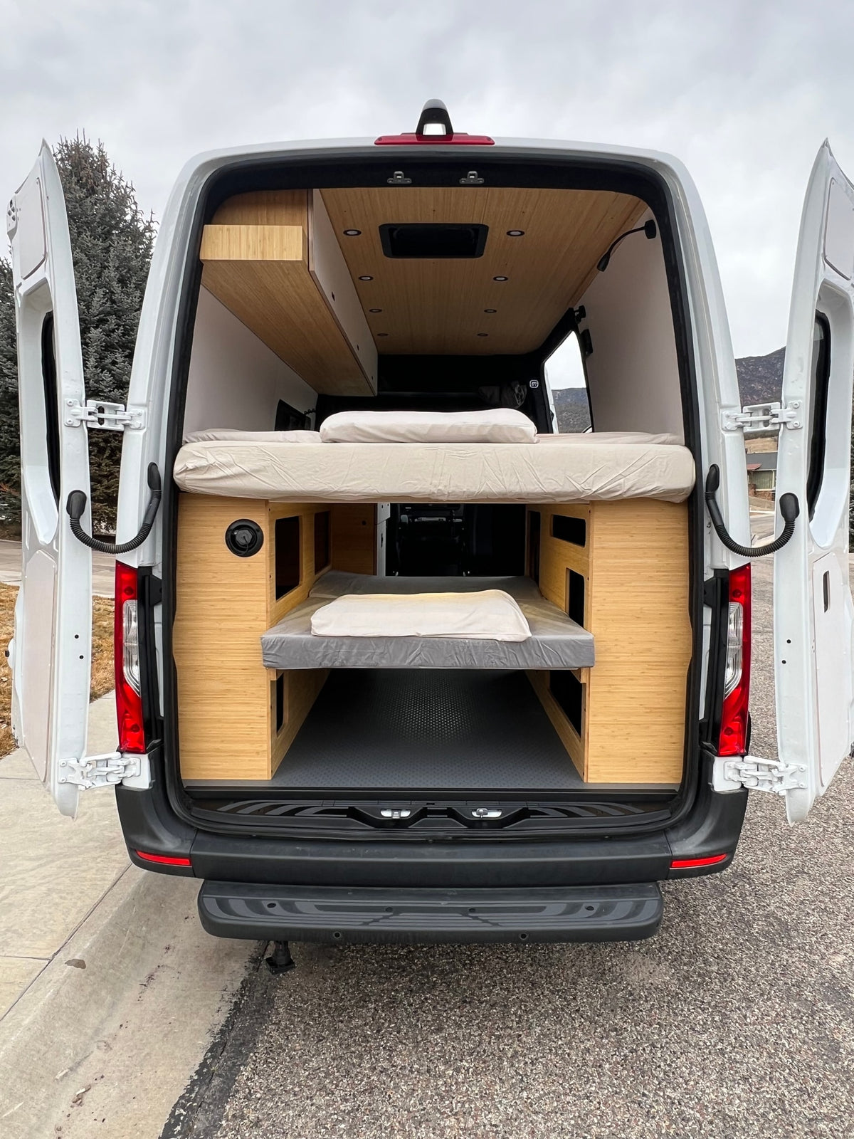 Explore in style! This RV rental camper van showcases its custom interior with two comfortable bunk beds and wooden paneling. — photo 18
