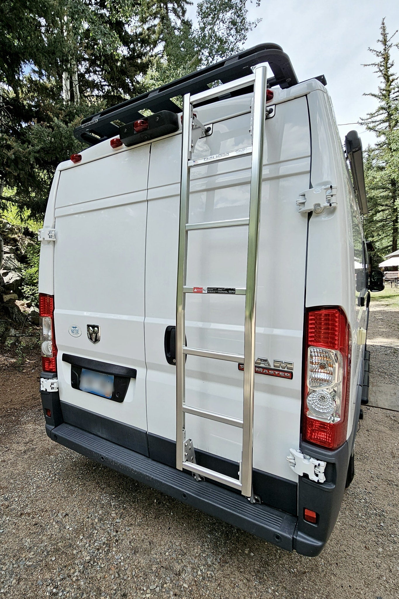  and a scenic forest view outside.|White RV rental van in a scenic Colorado mountain forest with an extended awning — photo 10