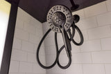 Modern black shower head with flexible hose and white subway tiles, typical of a well-appointed RV rental bathroom.
