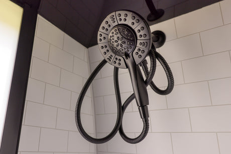 Modern black shower head with flexible hose and white subway tiles, typical of a well-appointed RV rental bathroom.