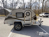 This rugged Boondock teardrop travel trailer RV rental, with its unique shape and open rear galley, is parked, ready for adventure.