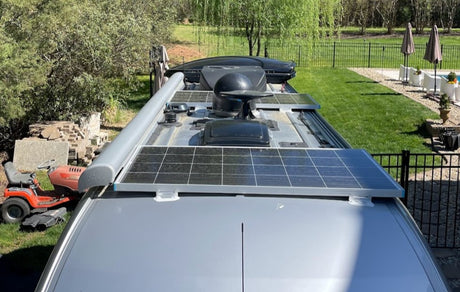 Overhead view of an RV rental roof with solar panels, awning, & antenna. Great for off-grid adventures!