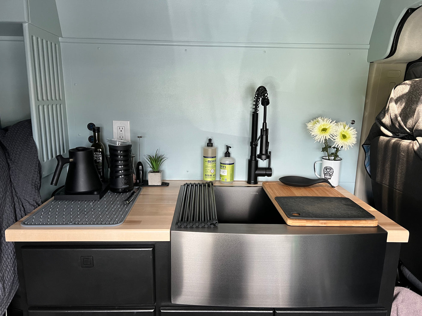 Enjoy this modern RV rental kitchen with a spacious sink, sleek black faucet, and ample organized counter space for your travels.