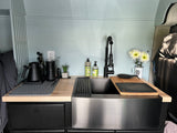 Enjoy this modern RV rental kitchen with a spacious sink, sleek black faucet, and ample organized counter space for your travels.