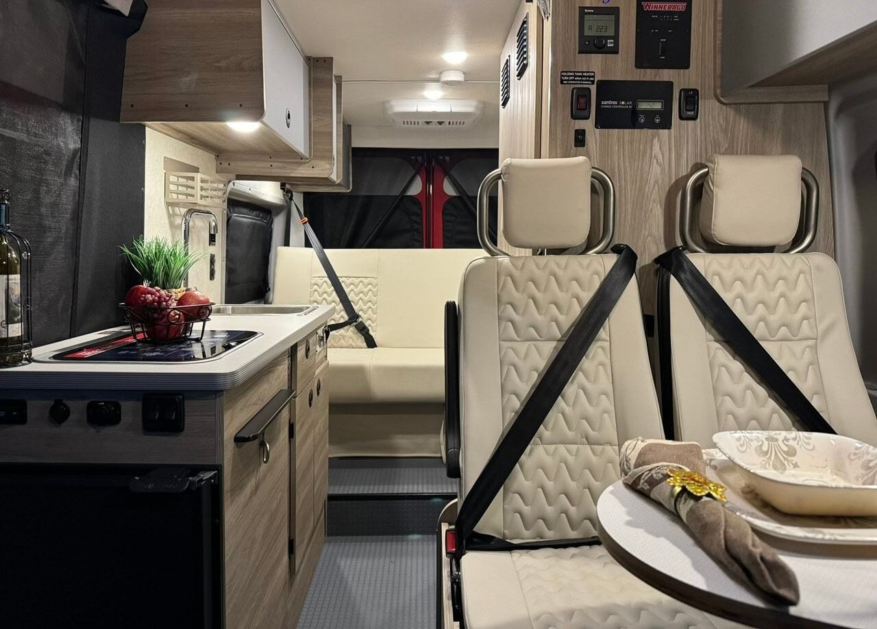  enjoying lake views from the comfortable interior.|Step into this RV rental! A compact camper van interior with kitchen — photo 3