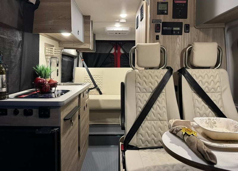  enjoying lake views from the comfortable interior.|Step into this RV rental! A compact camper van interior with kitchen — photo 3