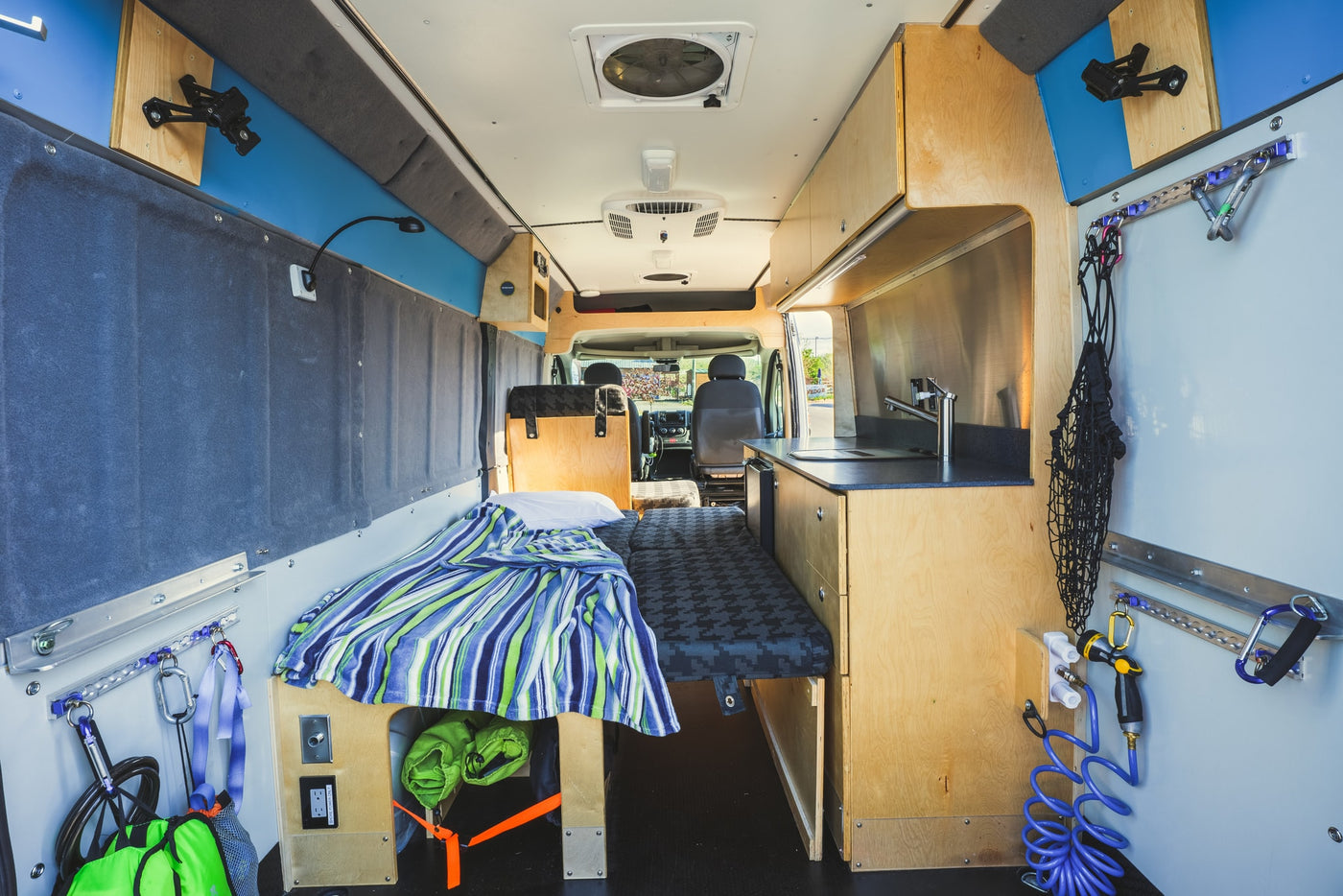  parked with its side door open revealing the custom interior.|Adventure-ready silver RV rental from Basecamp On Wheels — photo 3
