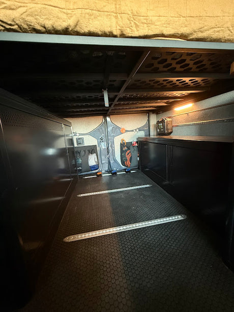 RV rental's spacious under-bed cargo: durable floor, tie-down tracks, and organized storage for adventure gear.