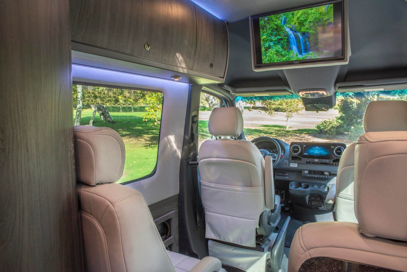  and large windows revealing a green park.|Luxury RV rental interior with a spacious — photo 9
