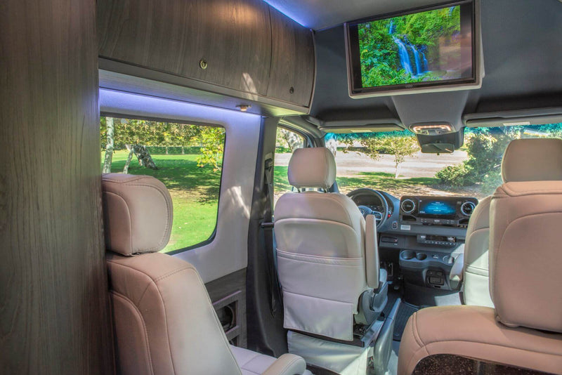  and large windows revealing a green park.|Luxury RV rental interior with a spacious — photo 9