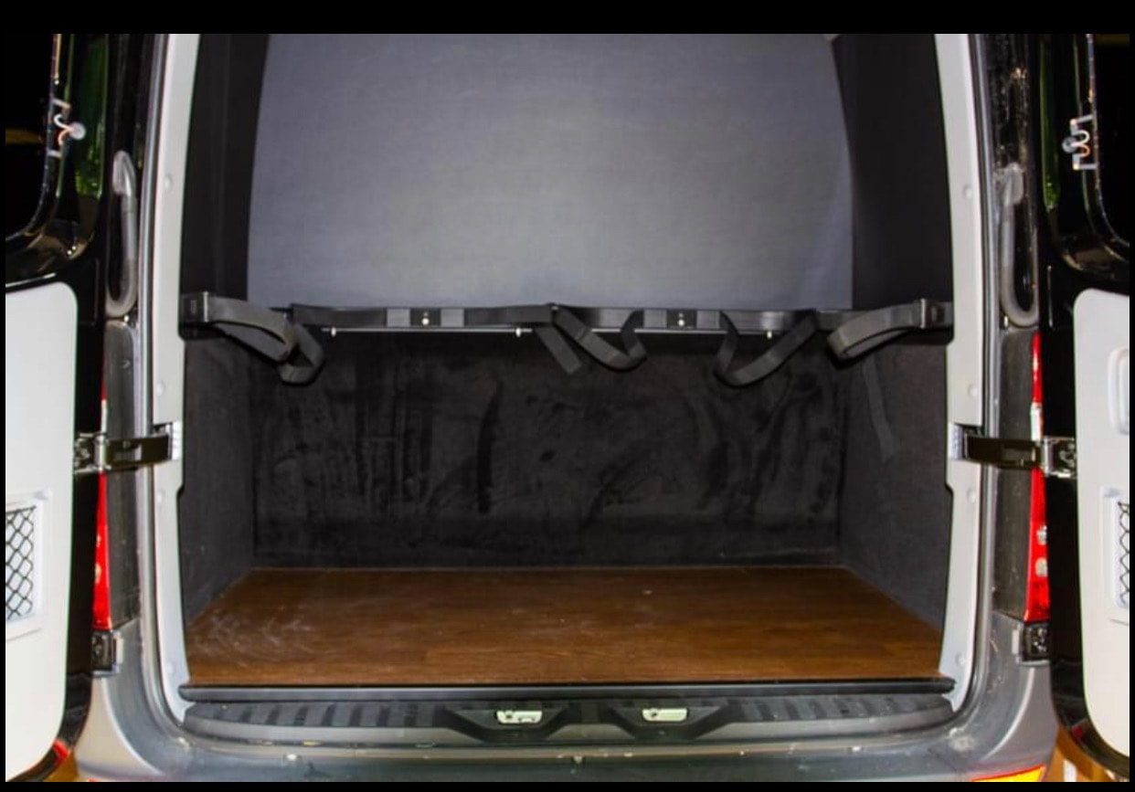 RV rental van's rear cargo area: wooden floor, lined walls, and adjustable straps for secure transport. — photo 3