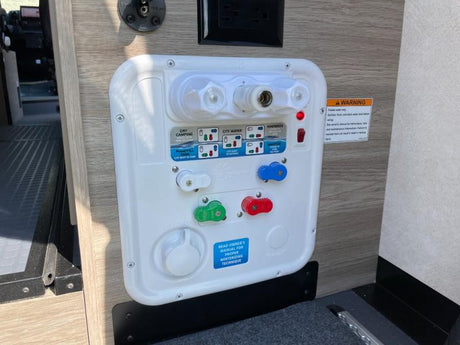 RV rental water system control panel with distinct knobs, ports, and labels for city water, tank fill, and winterizing settings.