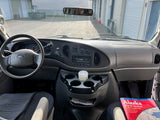 Inside an RV rental: a Ford van dashboard, steering wheel, and an Alaska map for road trip planning.