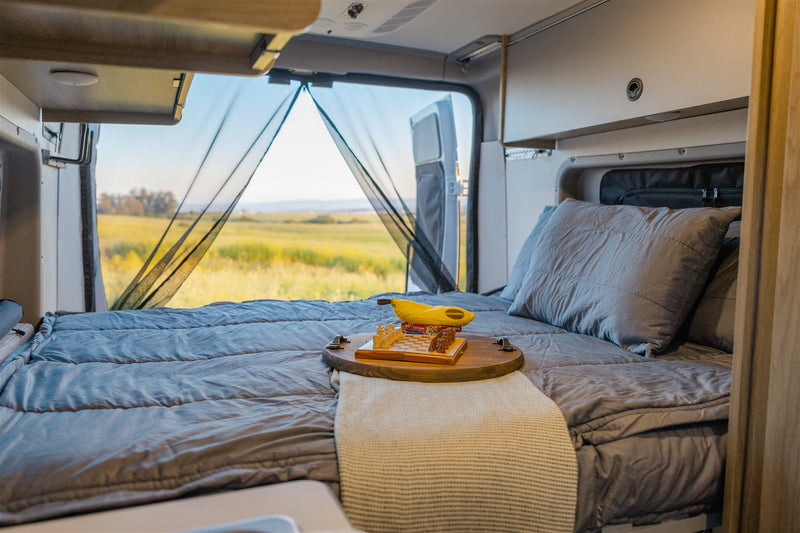  and comfortable seating. Perfect for travel adventures.|Cozy RV rental interior at sunset: table with wine & flowers — photo 20