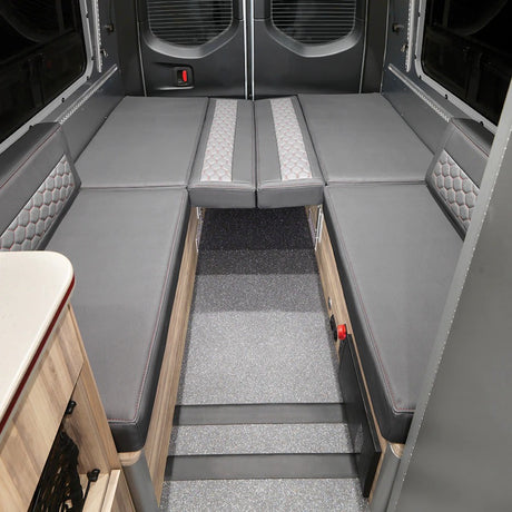 RV rental: Versatile gray U-shaped seating transforms into a comfortable bed, ready for your adventures. Ideal for camper van interiors.