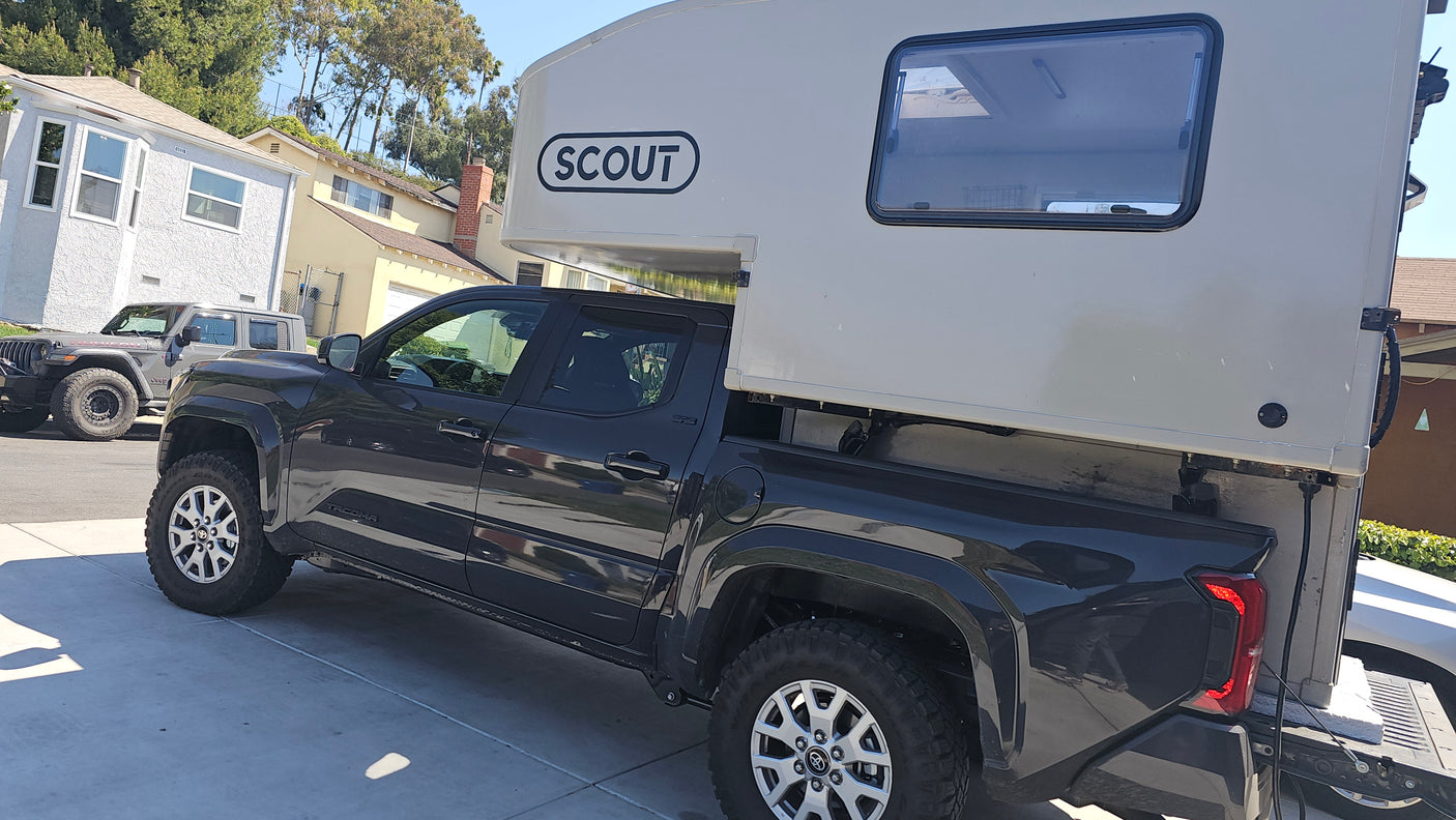 This dark gray Toyota Tacoma with a Scout truck camper could be an RV rental for your next off-road adventure.
