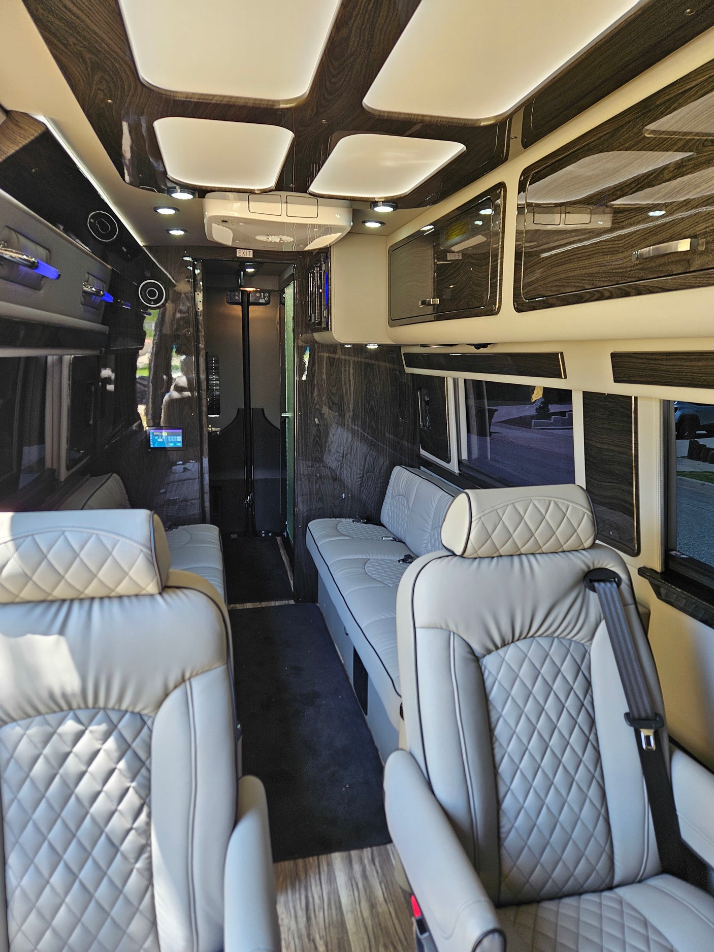 Luxury RV rental interior with plush, quilted seating, modern wood-grain finishes, and ambient lighting for comfortable travel.