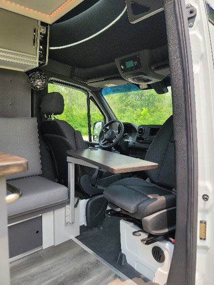 rv rental van's interior: a flexible table, cozy seating, and swiveling front seats form a complete living and dining area.