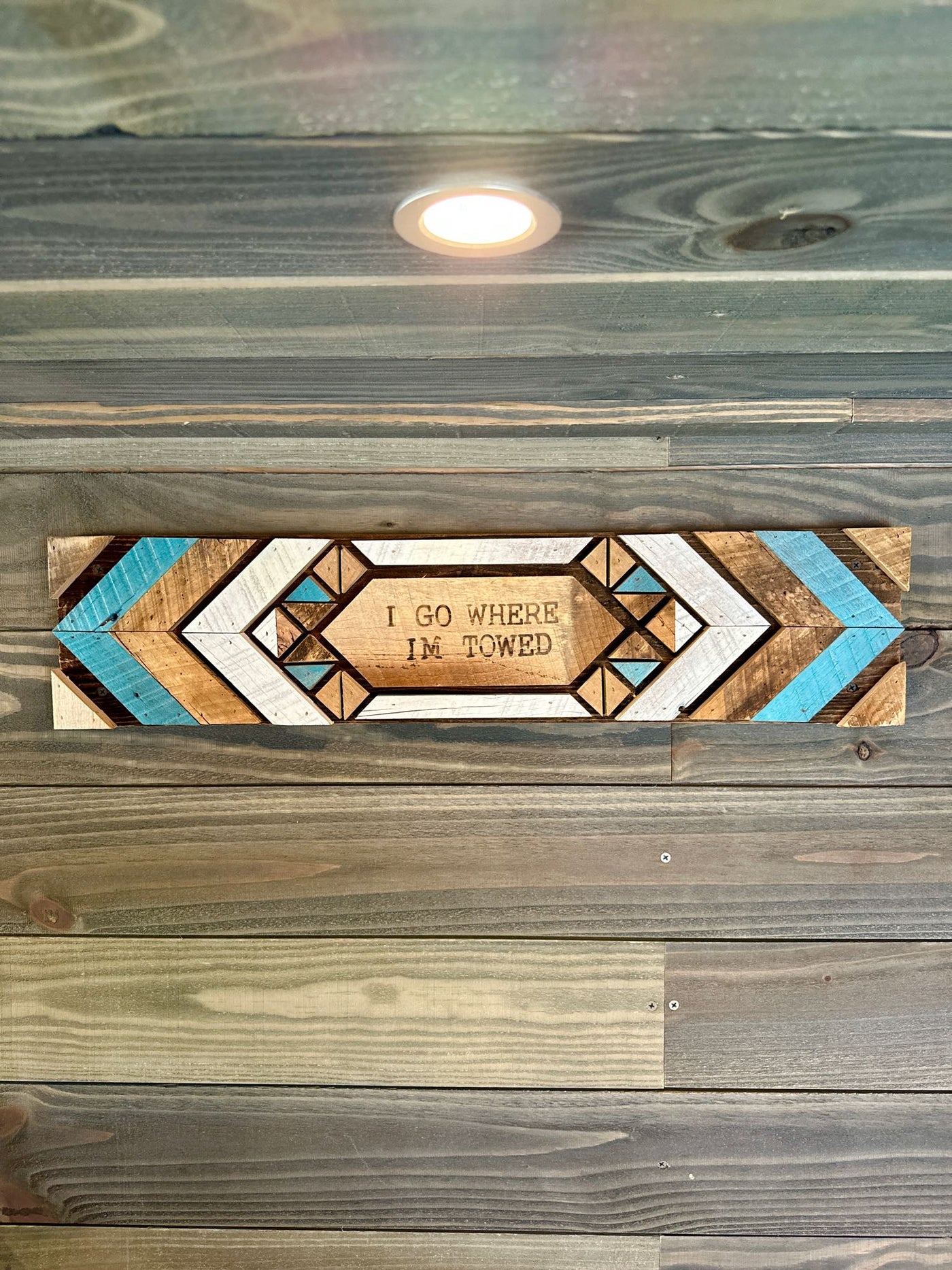  and lighted overhead cabinets.|Rustic RV rental interior featuring a wood-paneled living space — photo 15