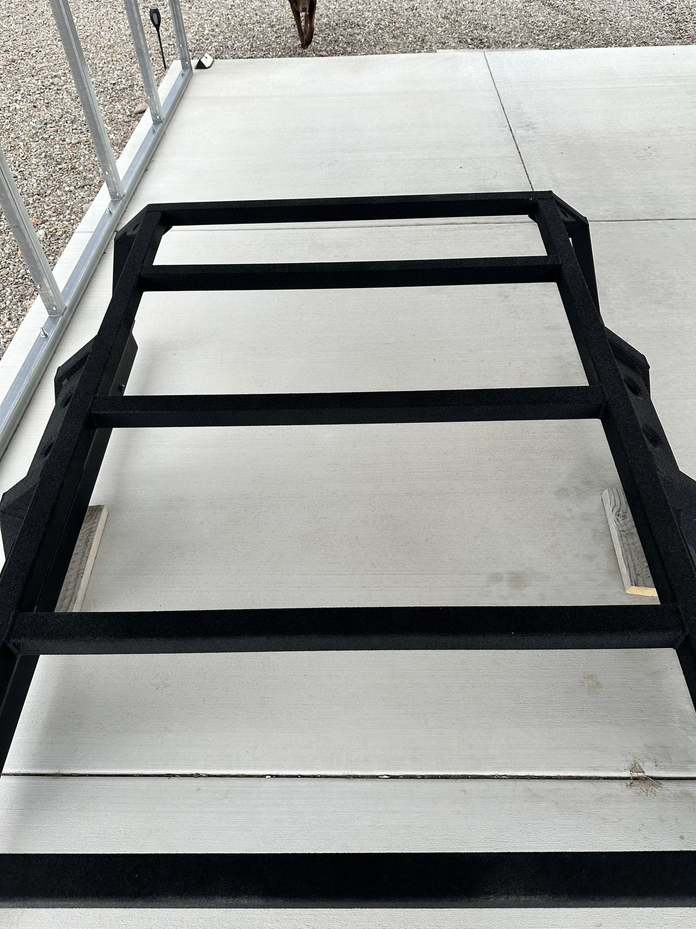 Looking down onto the rack from above showing the flat crossbar deck, the rhino lined black texture finish and the clean uncut tube tops with nothing ever mounted to them — photo 4